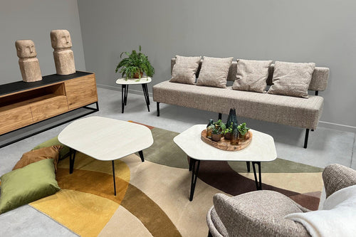 Beige zitbank, gecombineerd met unieke design salontafels van Belgische ontwerpster Christl Dekimpe.